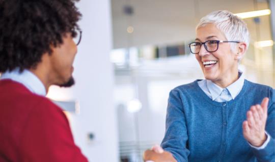 Woman and man shaking hands at job interview